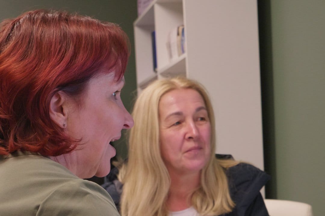 Dawn Richardson in conversation with a client at a desk in the clinic