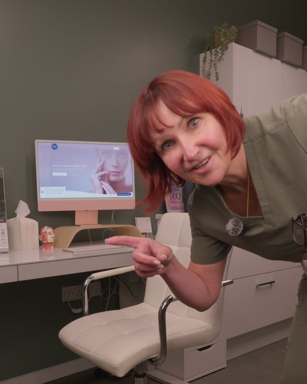 Dawn Richardson leaning in and smiling beside the desk in her clinic